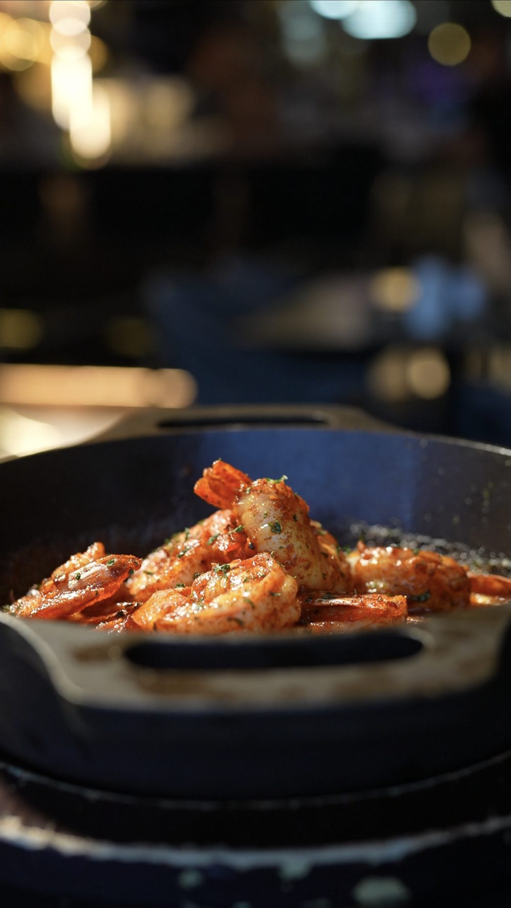 Shrimp sizzling in garlic butter in a cast-iron skillet